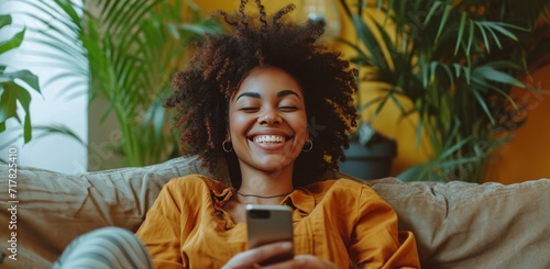 woman laughing on couch using smart phone