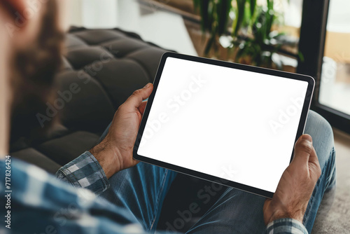 cropped view of man holding digital tablet with blank screen at home photo