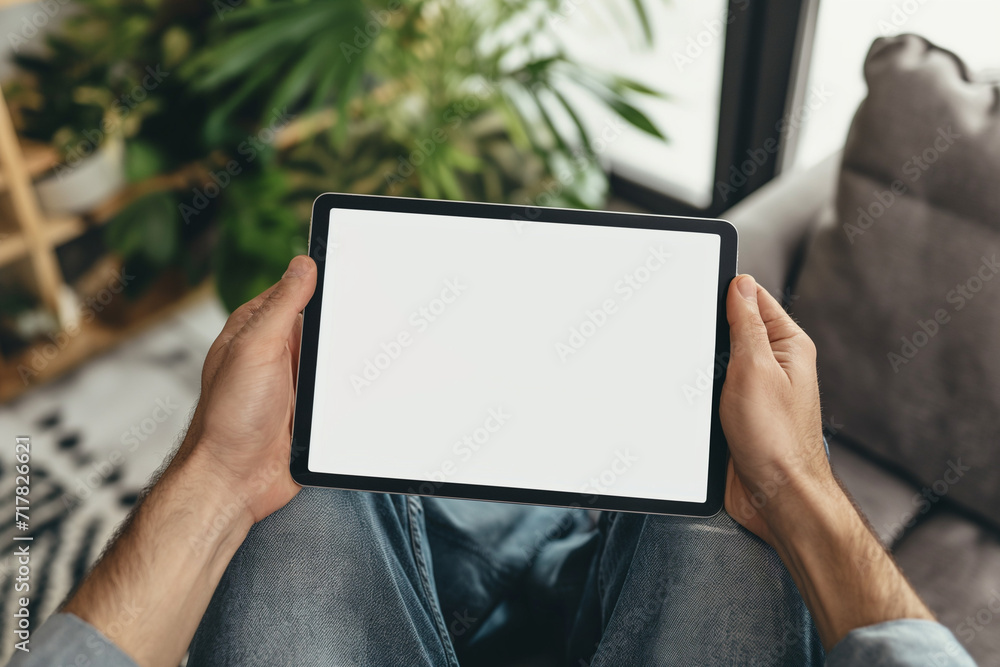 cropped view of man holding digital tablet with blank screen at home cropped view of man holding digital tablet with blank screen at home