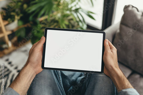 cropped view of man holding digital tablet with blank screen at home