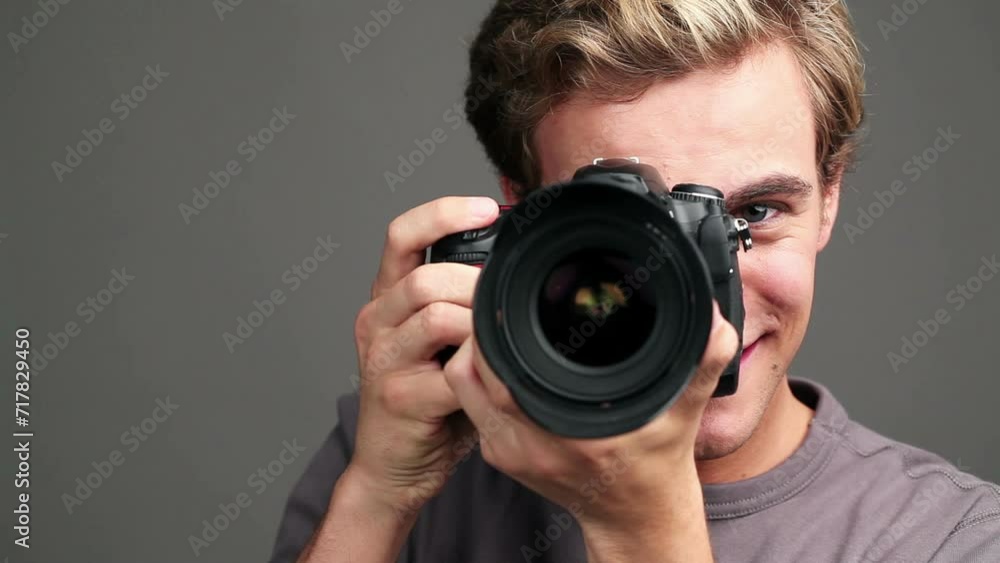 Photographer man, camera and face by studio background with smile, click or shooting at magazine job. Journalist, paparazzi persona and happy creative in photoshoot, lens and picture for newspaper Photographer man, camera and face by studio background with smile, click or shooting at magazine job. Journalist, paparazzi persona and happy creative in photoshoot, lens and picture for newspaper