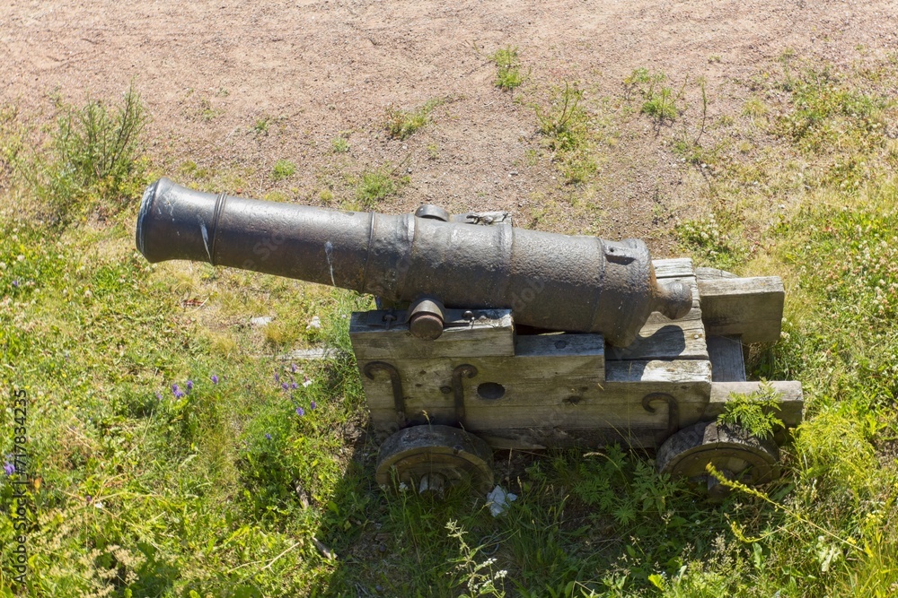 Ancient classic canon with wheels in old stone fortress.