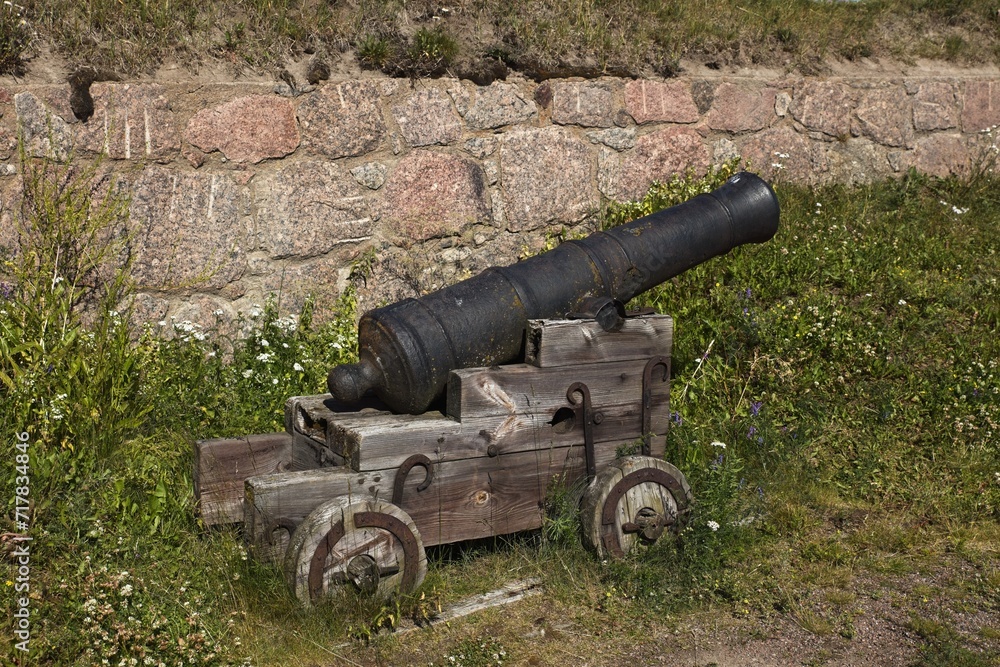 Ancient classic canon with wheels in old stone fortress.