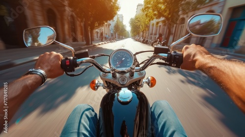 POV shot of young man riding on a motorcycle. Hands of motorcyclist on a street photo