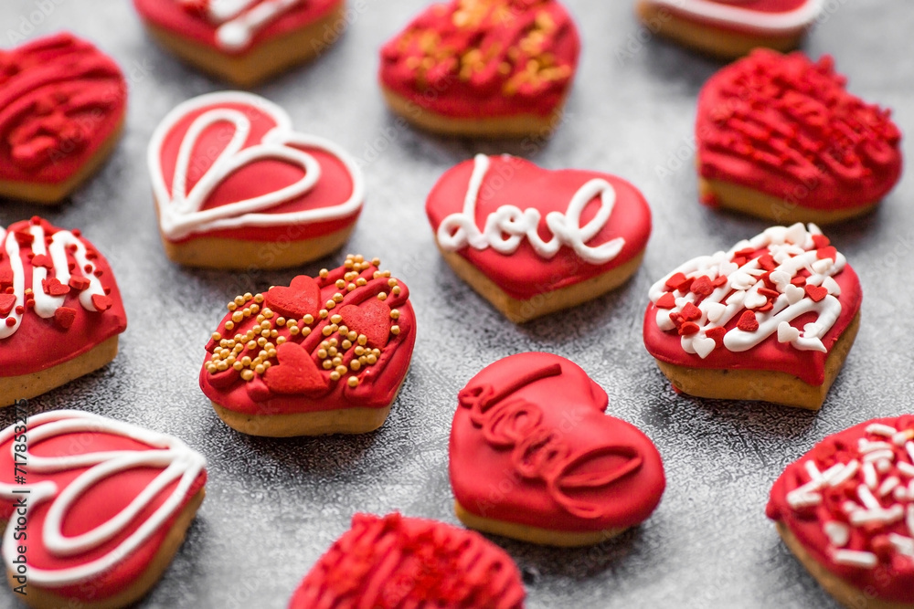 Homemade ginger cookies in the shape of a heart in red icing sugar. Delicious ginger cookies heart on a gray concrete background. Freshly baked gingerbread cookies for Valentine's Day. Homemade ginger cookies in the shape of a heart in red icing sugar. Delicious ginger cookies heart on a gray concrete background. Freshly baked gingerbread cookies for Valentine's Day.