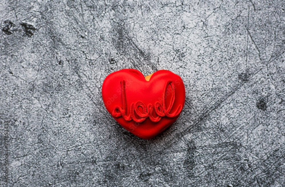 Homemade ginger cookies in the shape of a heart in red icing sugar. Delicious ginger cookies heart on a gray concrete background. Freshly baked gingerbread cookies for Valentine's Day. Homemade ginger cookies in the shape of a heart in red icing sugar. Delicious ginger cookies heart on a gray concrete background. Freshly baked gingerbread cookies for Valentine's Day.