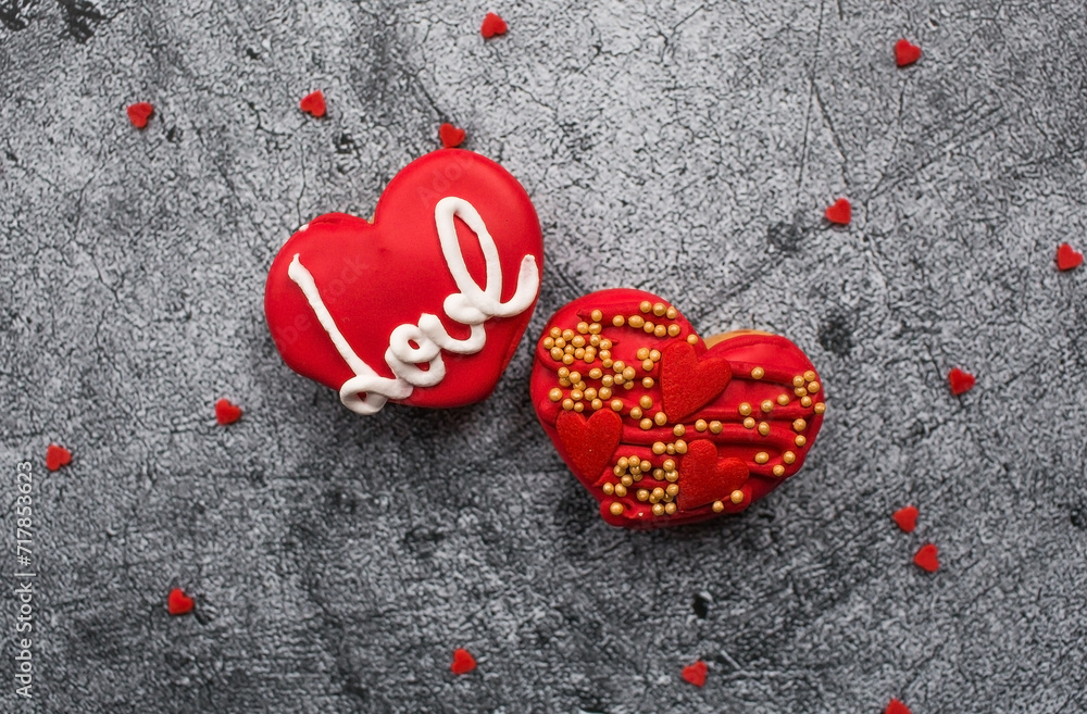 Homemade ginger cookies in the shape of a heart in red icing sugar. Delicious ginger cookies heart on a gray concrete background. Freshly baked gingerbread cookies for Valentine's Day. Homemade ginger cookies in the shape of a heart in red icing sugar. Delicious ginger cookies heart on a gray concrete background. Freshly baked gingerbread cookies for Valentine's Day.