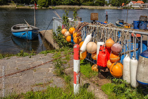 Bunte Bojen eines Fischers mit Boot am Schlei-Ufer