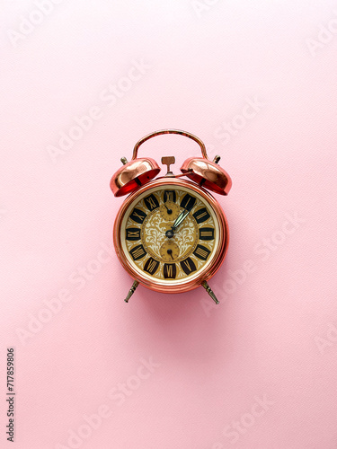 Alarm clock on a pink background, time 