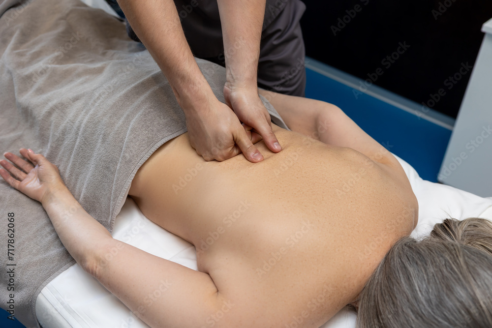 Fototapeta premium Close up of female patient having back massage in a clinic