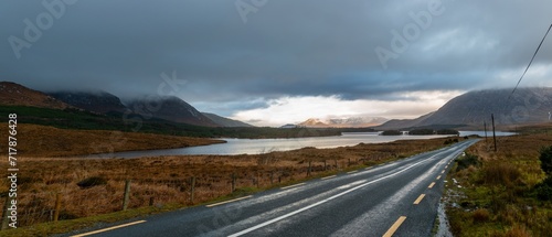 Long road with snow-capped mountains in the background and Lake Corrib in a wintry Irish scene