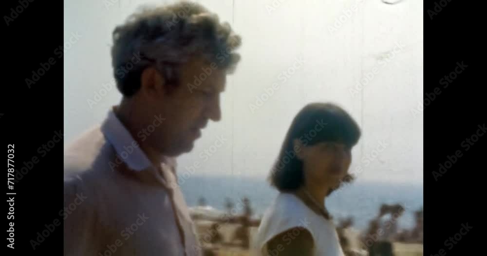 Woman, man on sea beach resort backdrop. Happy portraits on beach holiday. Crowded city beach with people. Popular coastline near ocean. Summer tourism. Vintage color film. Family archive. Retro 1980s Woman, man on sea beach resort backdrop. Happy portraits on beach holiday. Crowded city beach with people. Popular coastline near ocean. Summer tourism. Vintage color film. Family archive. Retro 1980s