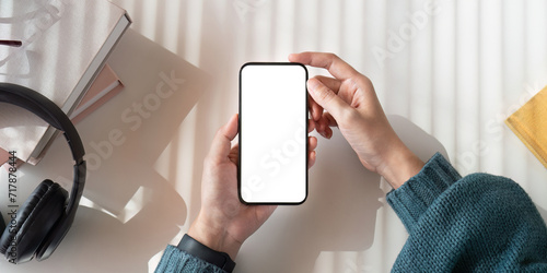 Obraz na plátně Top view mockup image of a woman holding mobile phone with blank white screen wh