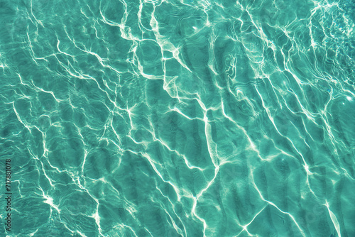 Blue water surface viewed from above in outdoor sea, sun reflection, dimply. Surface Abstract Background. Clear water in sea with ripple in clean aqua liquid. Summer wallpaper blue background