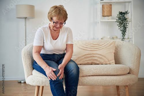 Pain in the leg. Senior elderly woman is at home in the living room