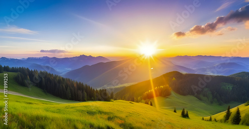 Panorama of sunset in the mountains with forest  green grass and big shining sun on dramatic sky