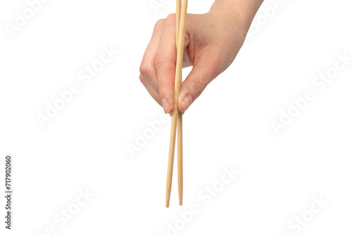 Female hand holding wooden sushi chopsticks isolated on white background. photo