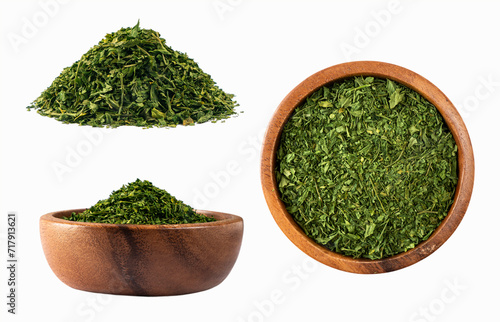 Dried parsley in a wooden bowl isolated on white background. Set of parsley with copy space for text. Dried natural herbs isolated on white. Parsley spice leaves on white background.