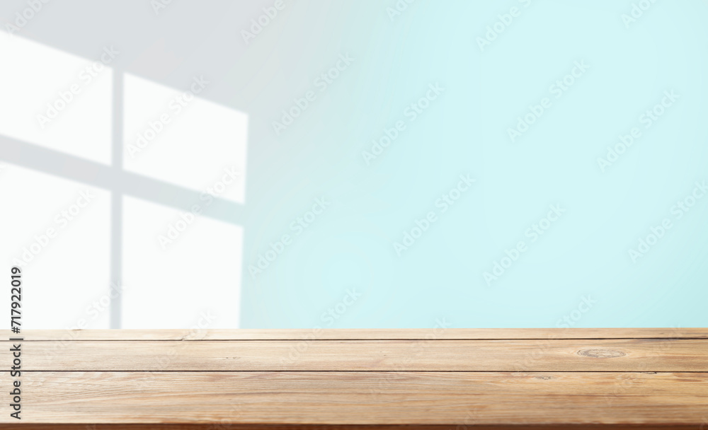 Naklejka premium empty table with window shadow on light wall background for product mockup display. kitchen interior theme