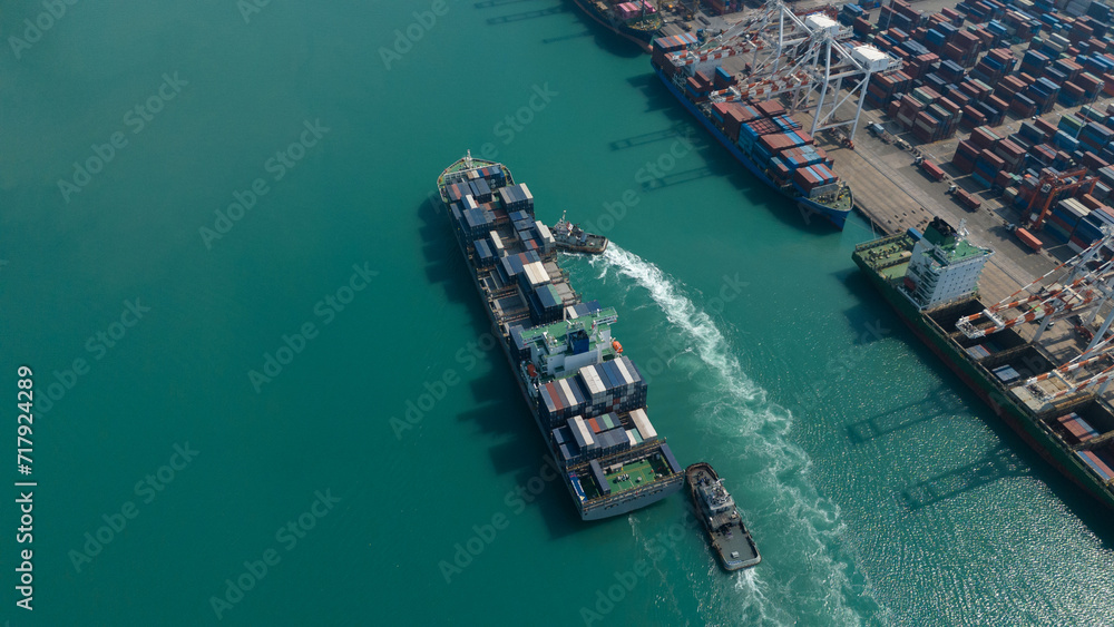 Global logistics business Aerial top view over an international cargo ship at the industrial import and export port preparing to load containers with a large container ship.