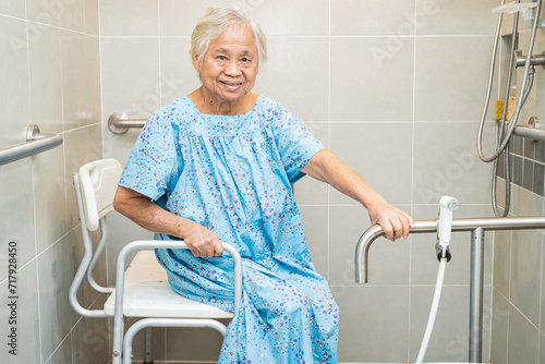 Asian elderly woman patient use toilet bathroom handle security in nursing hospital, healthy strong medical concept. photo