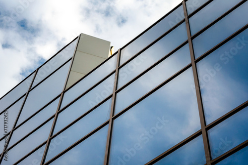 reflection of blue sky with clouds in an office building window #717932629