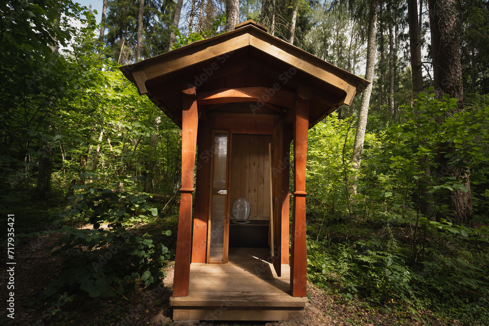 Wooden toilet outdoors in the forest in Estonia in summer. Wooden toilet outdoors in the forest in Estonia in summer.