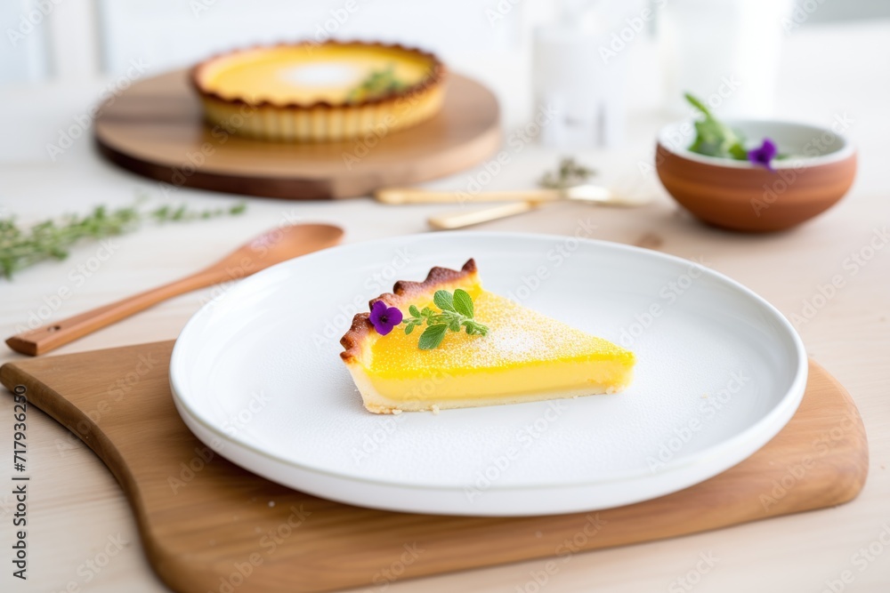 lemon tart with a slice cut out, on a white plate