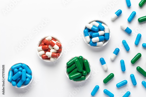 Fototapeta Naklejka Na Ścianę i Meble -  Dietary supplements and different vitamins, various colourful pills on white background, assorted pharmaceutical medical capsules close-up, top view, beautiful composition, pattern. Minimal design.