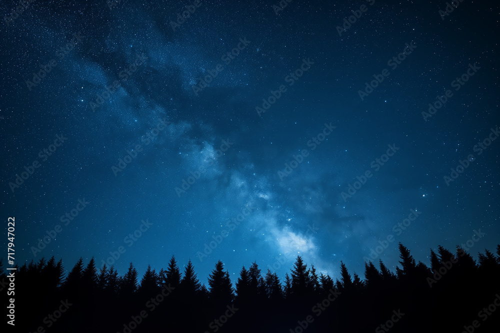 Blue dark night sky with many stars above field of trees. Milkyway cosmos background