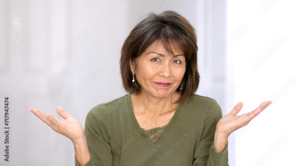 Playful attractive woman looking at camera smiling enjoying making funny hand finger gestures laughing at humor. Playful attractive woman looking at camera smiling enjoying making funny hand finger gestures laughing at humor.