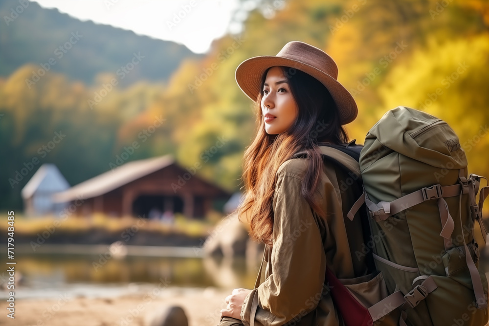 Asian female backpacker traveling alone explores while walking in the nature forest with happiness and fun in the forest enjoying their vacation.