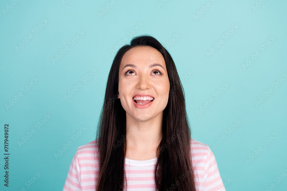 Photo of pretty excited mixed race mestizo lady dressed striped t-shirt looking up empty space isolated teal color background Photo of pretty excited mixed race mestizo lady dressed striped t-shirt looking up empty space isolated teal color background