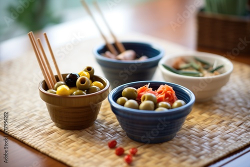 small bowls with assorted olives beside breadsticks photo