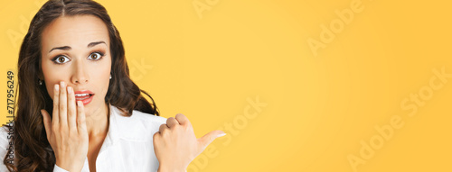 Fotografie Portrait image of excited surprised shocked astonished businesswoman pointing away side with finger