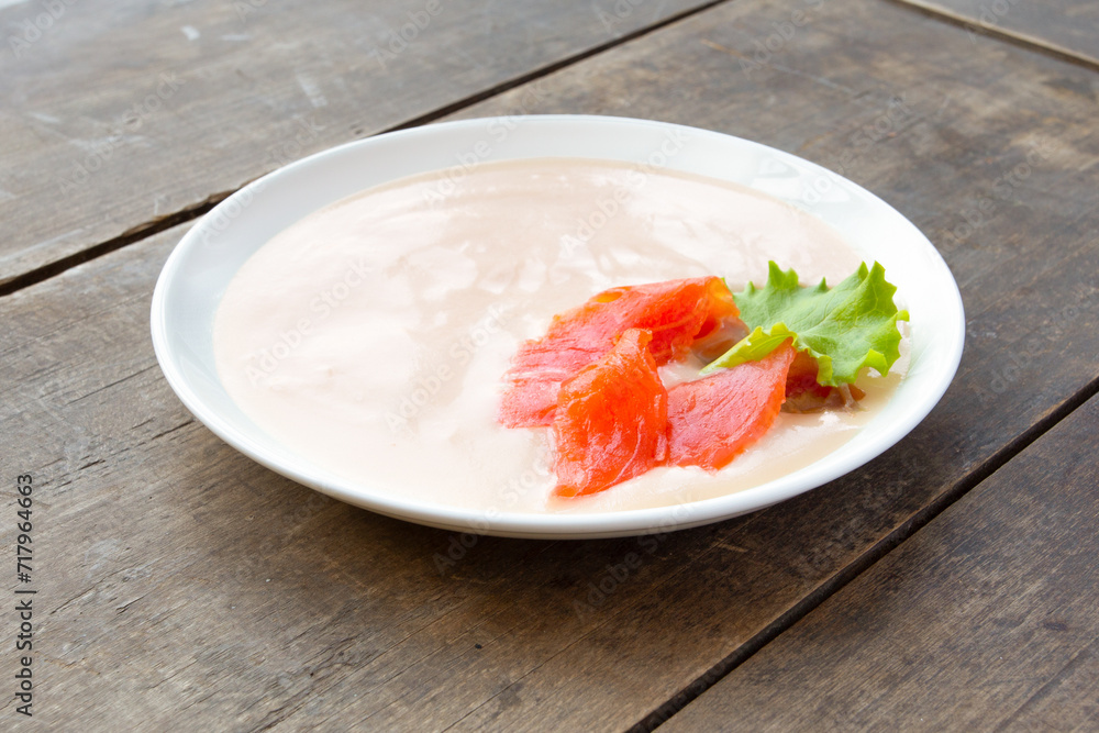 Plate of cream soup with red fish and salad on a wooden background. Dietary menu. Plate of cream soup with red fish and salad on a wooden background. Dietary menu.