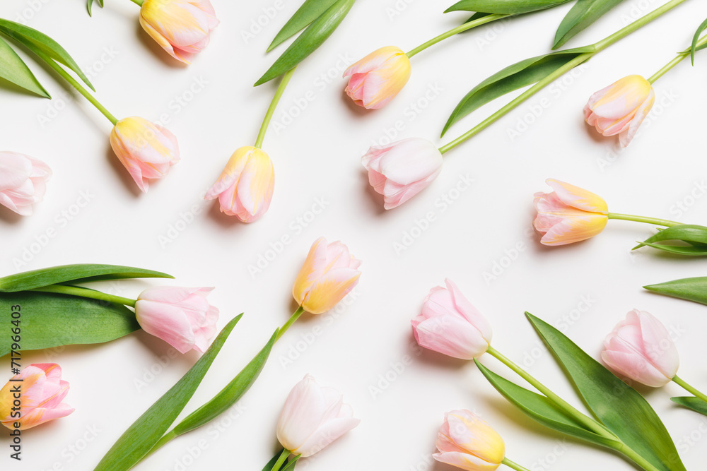Light pink and yellow blooming tulips flowers minimal floral pattern over white background. Spring holiday banner, happy easter, mothers day concept. Flat lay, top view, copy space Light pink and yellow blooming tulips flowers minimal floral pattern over white background. Spring holiday banner, happy easter, mothers day concept. Flat lay, top view, copy space