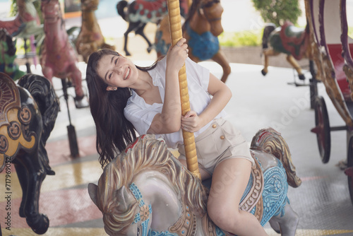 couple asian man and woman dating and riding on horse at Carousel amusement park. Concept happy and lovely life of teenager.