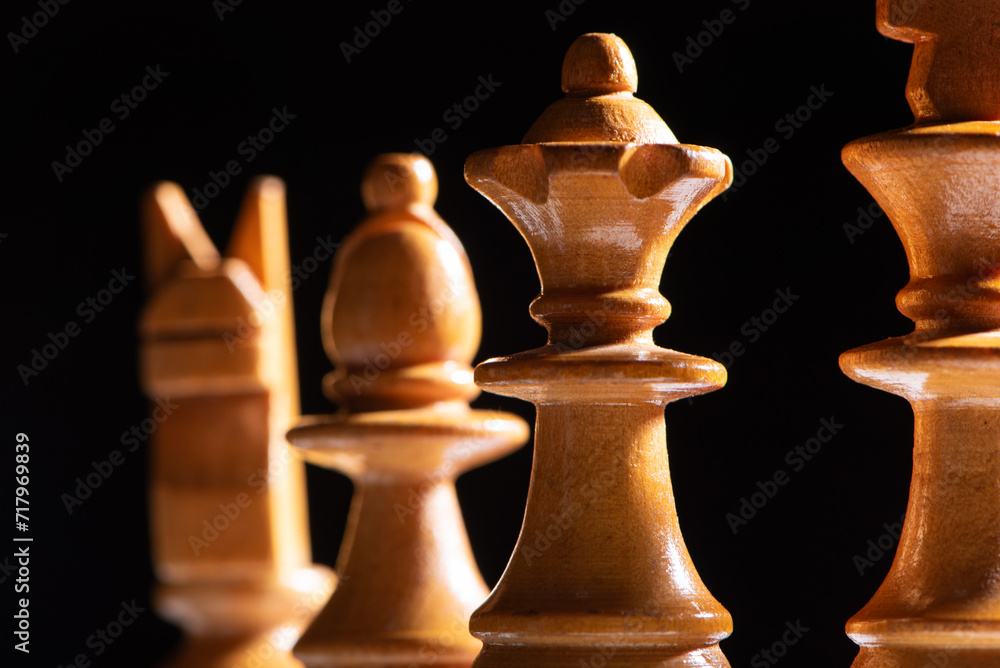 Chess pieces,beautiful old chess pieces on a board, black background, selective focus. Chess pieces,beautiful old chess pieces on a board, black background, selective focus.