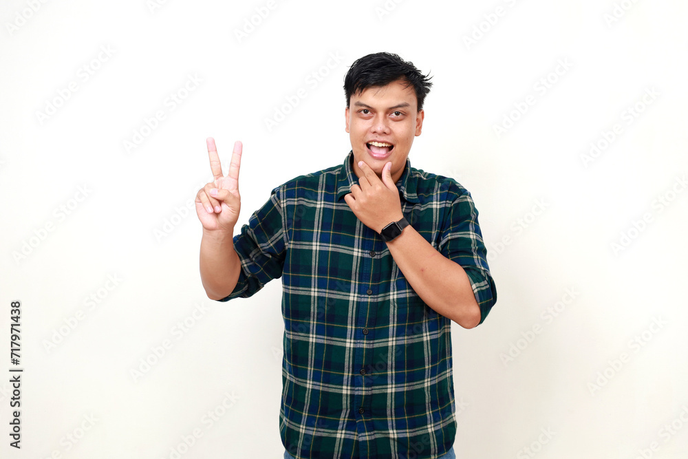 Portrait of young adult Indonesian man standing while showing two fingers. Isolated on white Portrait of young adult Indonesian man standing while showing two fingers. Isolated on white