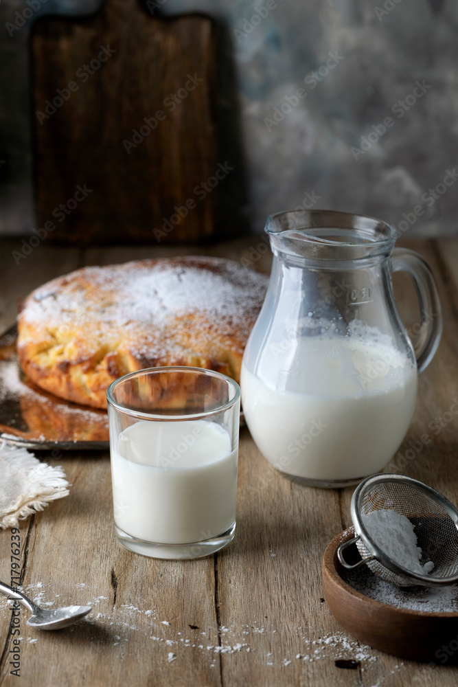 Homemade pie and milk poured into a glass glass on a rustic table Homemade pie and milk poured into a glass glass on a rustic table