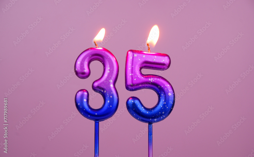 Colorful birthday candles burning on pink background. Number 35. Colorful birthday candles burning on pink background. Number 35.
