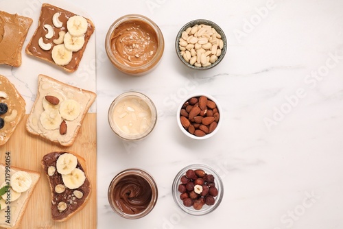 Toasts with different nut butters and products on white marble table, flat lay. Space for text