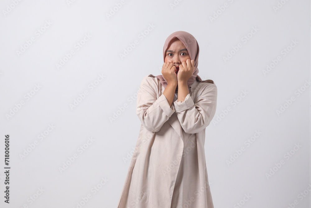 Portrait of frightened Asian hijab woman in casual suit making shocked hand gesture, showing surprised and scared expression. Isolated image on white background Portrait of frightened Asian hijab woman in casual suit making shocked hand gesture, showing surprised and scared expression. Isolated image on white background