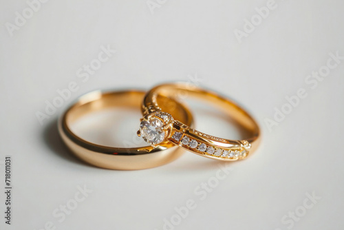 two wedding rings, gold with diamonds on a neutral background