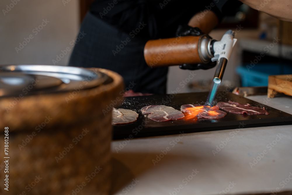 Grilling beef slices with fire-canned gas on the table, Japanese food, Street food in Thailand. Grilling beef slices with fire-canned gas on the table, Japanese food, Street food in Thailand.