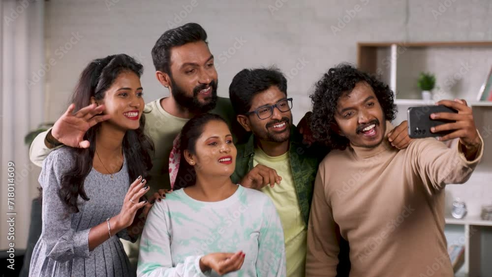 Group of joyful friends talking on video call or doing live stream on mobile phone - concept of social media sharing, weekend gathering and reunion Group of joyful friends talking on video call or doing live stream on mobile phone - concept of social media sharing, weekend gathering and reunion