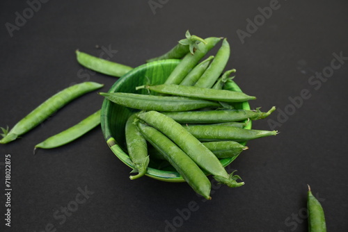 Fresh Green peas on black background. There is a lot of vitamins  and Minerals in it. The pea is most commonly the small spherical seed or the seed. Popular vegetable of all over world. 