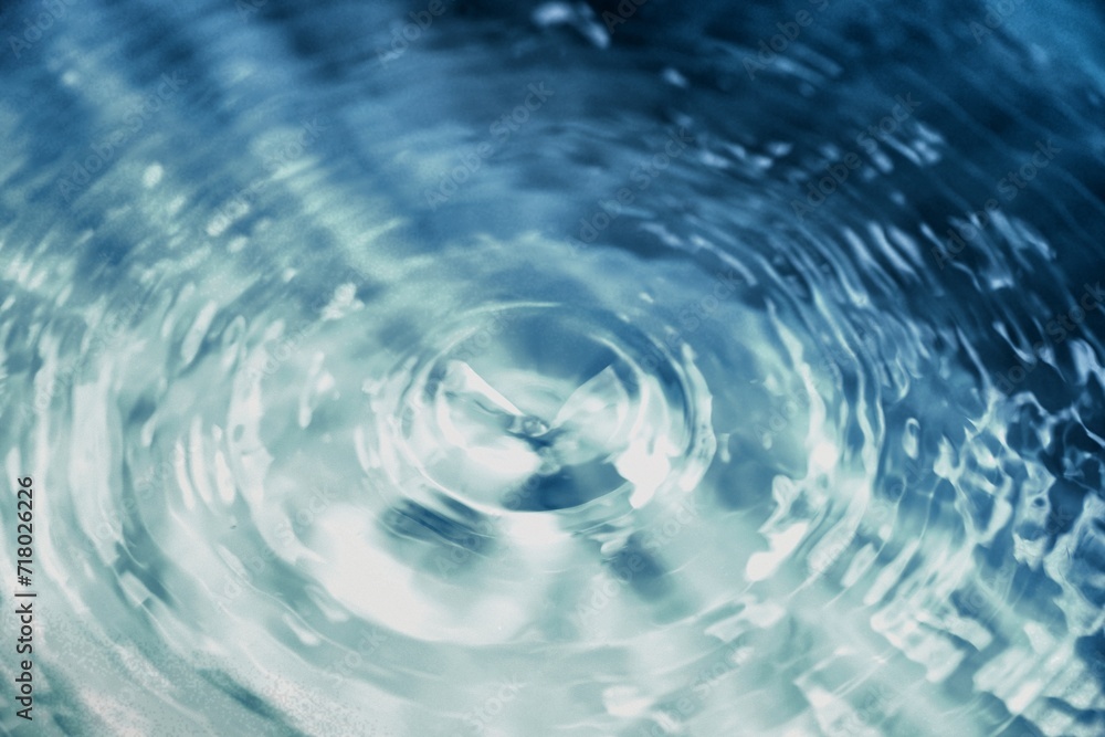 Bluewater waves on the surface ripples blurred. Defocus blurred transparent blue colored clear calm water surface texture with splash and bubbles. Water waves with shining pattern texture background. Bluewater waves on the surface ripples blurred. Defocus blurred transparent blue colored clear calm water surface texture with splash and bubbles. Water waves with shining pattern texture background.