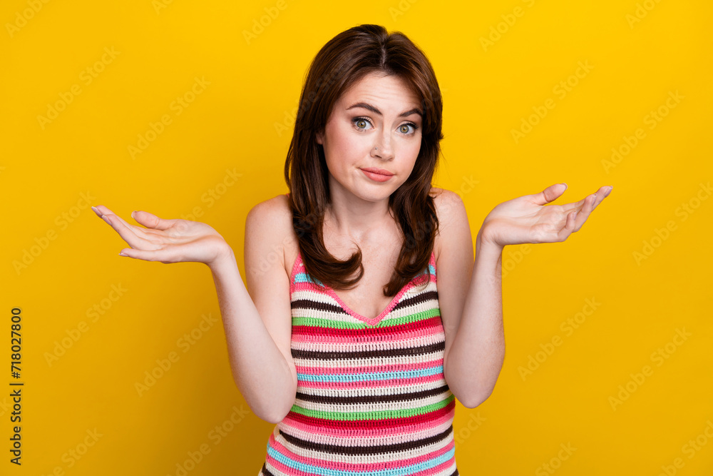 Portrait of confused woman with nose piercing dressed knitwear top raising palms up shrug shoulders isolated on yellow color background Portrait of confused woman with nose piercing dressed knitwear top raising palms up shrug shoulders isolated on yellow color background